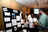 Alex Charles, sophomore engineering major, talks with George Moss, associate professor of mathematics, about his research project during the Scholarship Symposium poster presentations.  - Photo by Anne Richoux