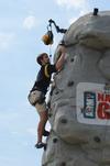 Daniel Stands, junior biblical studies in languages major, reaches the top of a rock climbing tower during May Day festivities. - Photo by Jacob Moore