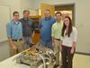 The Trench Cleaning Robot as designed by Union University Engineering seniors Aaron Porterfield (1st from left), Jeff Maharrey (4th from left) and Rachel Quinn (1st from right) flanked by satisfied Kellogg's representative Albert Shepherd and Jerry Avent (2nd and 3rd from left). - Photo by Morris Abernathy