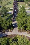 Graduates walk alongside faculty members in the processional from the PAC to the Great Lawn for spring graduation. - Photo by Kristi McMurry