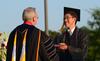 David S. Dockery, president of the university, presents biology major David Koh with a diploma during spring graduation. - Photo by Jacob Moore