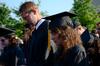 Luke Allison and Jessica Attig, mathematics graduates, bow their heads during the opening prayer at spring graduation.  - Photo by Ebbie Davis