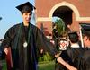 Natalie Wittmen, Spanish graduate, fist bumps a fellow graduate after receiving her diploma at spring graduation.  - Photo by Ebbie Davis
