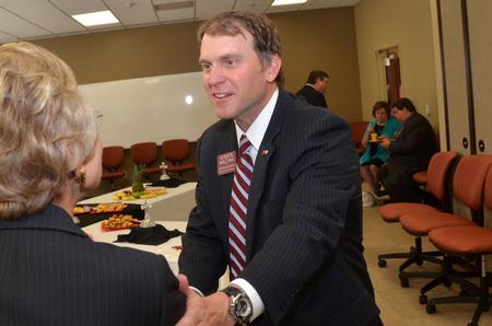 Jan Bould, assistant to the president for constituent relations, greets John McDearman, III, executive vice president of Wilson Bank and Trust, at the beginning of the Hendersonville dedication ceremony.