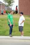 Trey Weise, junior philosophy major, talks with Scott Huelin, director of the honors community, while waiting for new students to arrive for move-in day. - Photo by Anne Richoux