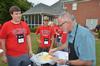 Rich Grimm, senior vice president for enrollment services, dips a helping of ice cream for new student Brady Teague at the annual ice cream social hosted by the Dockerys. - Photo by Morris Abernathy