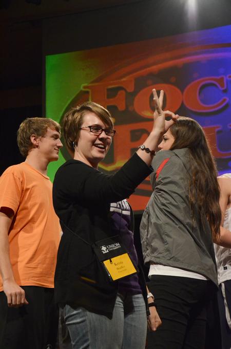 Krista Bradley, senior teaching English as a second language major, gives her focus group the "OK" sign before participating in a rock-paper-scissors tournament between focus leaders during the annual SAC game show.