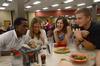 Denis Bisangwa, sophomore business administration major, Kara Lyons, sophomore psychology major, Lindsay Olford, senior English major, and Zac Calvert, junior intercultural studies major, listen to African music from their iPod in a glass while eating in The Brewer Dining Hall. Bisangwa, Lyons and Calvert all grew up in different countries in Africa and were reminiscing over their high school dances.  - Photo by Ebbie Davis