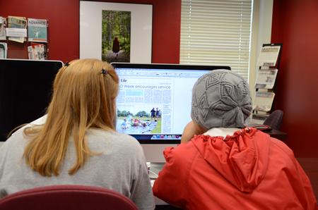 Students on the Cardinal & Cream staff work on creating a page for the Life section of the student newspaper.
