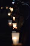 Students hold candles along the sidewalk circling Miller Tower as homicide-loss survivors walk together in remembrance of their loved ones. - Photo by Jacob Moore