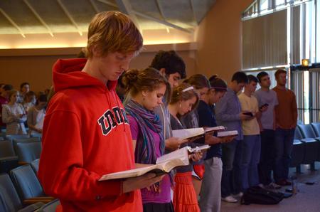 Students follow along as Larry York, pastor of Crossroads Baptist Church in Woodlands, Texas, reads the Scriptural account of Jesus healing the paralytic, found in Luke 5.