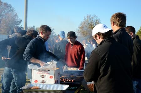 Chris Hawks (left), junior accounting major, grills hamburgers and hotdogs for the pre-game tailgate celebrating Senior Night for the soccer teams. 