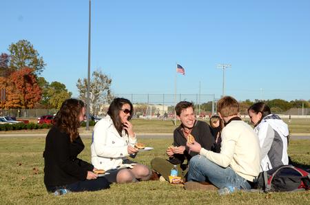 Elizabeth Oakes, Rachel Robbins, Peter Riggs, Caisie Jordan and Will Burke chat and laugh together during the pre-game tailgate celebrating Senior Night for the soccer teams.