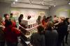Guests visit the senior show of art major Kayla Ellingsworth, who used a variety of graphic design techniques to create a store-like atmosphere for her exhibit called "The Cakejar." - Photo by Jacob Moore