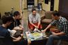 Jared Dauenhauer, assistant director of student leadership and engagement, Ryan Substad, senior engineering major, Jacob Kirkland, senior sports medicine major, and Tim Call, assistant residence director, play a board game together in the Bowld Student Commons.  - Photo by Anne Richoux