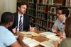 Jason Crawford, assistant professor of English, chats with a group of students in the library.  - Photo by Kristi McMurry