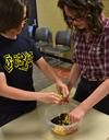 Kaitlyn Pindak, sophomore music education major, and Cameron Wilson, sophomore english major, add lime juice as the finishing touch to the southwestern black bean salad during residence life's event Cooking with Class.  - Photo by Olivia Wallace