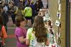 Vanessa Jackson, mail services assistant, chats with one of the artists at the annual Mother's Day pottery sale.  - Photo by Olivia Wallace