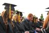Amanda Dick, biology graduate, Jessica Duck, psychology graduate, and Jeffrey Edwards, psychology graduate, bow for prayer at the beginning of Spring Graduation. - Photo by Anne Richoux