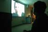 Junior filmmaker Trae Cadenhead, digital media studies major, watches his film "Within a Room Somewhere" with a scholarship symposium crowd. - Photo by Kristen Nicole Sayres
