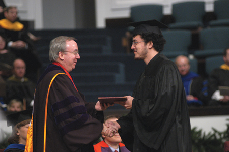 President David S. Dockery presents Art Wong with his degree during fall graduation.