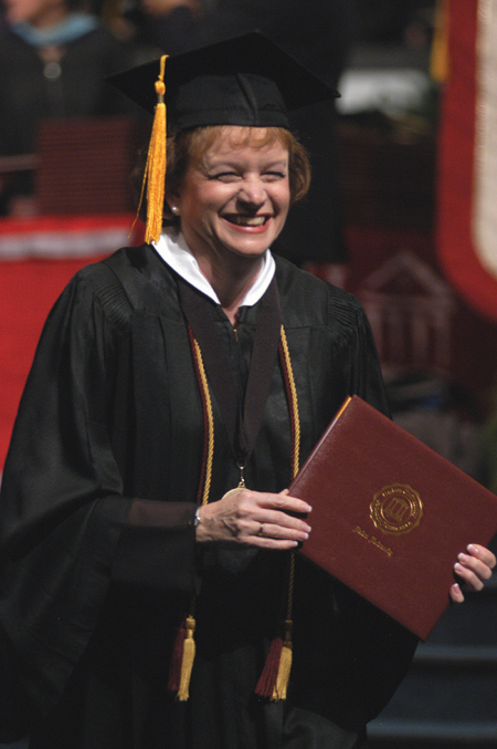 Provost administrative assistant Linda Baker flashes a big smile after receiving her degree at fall graduation.