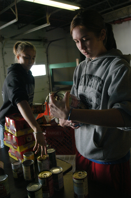Freshmen Jenny Beffa & Corrie Rose organize cans at RIFA during Day of Remembrance.