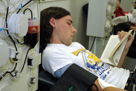 Senior David Clark, creative writing major, uses his donation time to get caught up on some reading. The entire plasma donation process takes roughly an hour and a half which donors can spend relaxing, reading magazines or enjoying the movie shown on various televisions throughout the donation room.