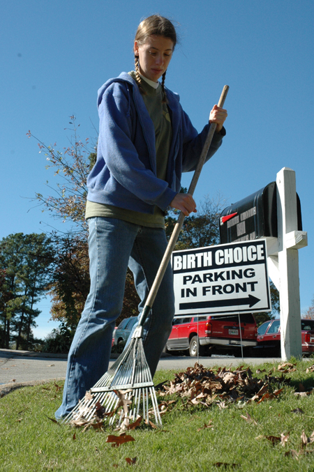 Art major Heather Couch rakes leaves at Birth Choice during Day of Remembrance.