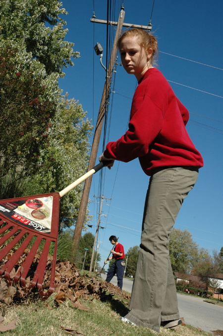 Junior Melody Pickerill rakes leaves at Birth Choice during Day of Remembrance.