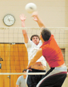 Junior Clayton Sanderson goes up for a block as two of the now numerous lower division teams battle late one Monday night in a game of intramural volleyball. - Photo by Kristen Hiller