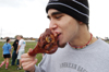 Sophomore Josh White chomps a turkey leg at the second annual Turkey Bowl sponsored by Young Alums. - Photo by Kristen Hiller