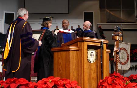 Provost Carla Sanderson and Dr. Richard Joiner placed a doctoral hood on Barry Black while he was receiving an honorary doctor of divinity degree during the fall graduation ceremony.