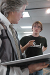 <i>C&C Photo Story:</i> Seeking advice from photojournalism instructor Jim Veneman, Tyler Malone brainstorms about how to arrange his photographs
for the symposium. - Photo by Kathleen Murray