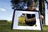 <i>C&C Photo Story:</i> Tyler Malone prepares for his pinhole camera selfportrait image by steadying a matted frame to encompass his likeness. - Photo by Kathleen Murray
