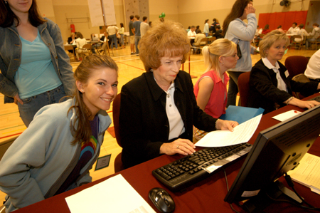 Provost administrative assistant Linda Baker helps an eager incoming freshman register for classes.