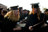 Chemistry graduate Kiera Knappman takes a close look at biology graduate Lindsay Barnes' diploma during spring graduation. - Photo by Brad Moore