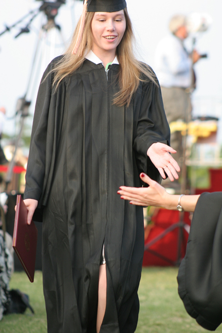 A graduate receives a high-five after walking the line at spring graduation.