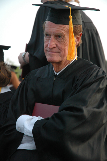 Bobby Morris tightly holds his physical education and health degree during spring graduation.