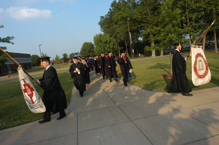 The graduate and faculty processional lines diverge to file onto the Great Lawn.