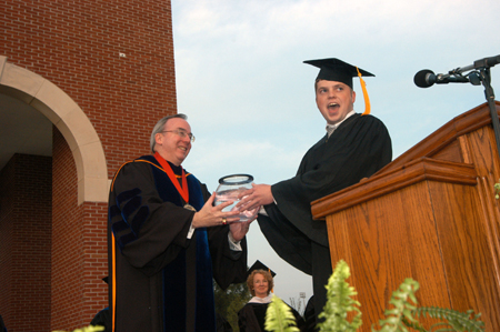 Senior Class President Brandon Nelms presents President Dockery with a fish to represent the senior class gift of a wall-sized aquarium for White Hall.