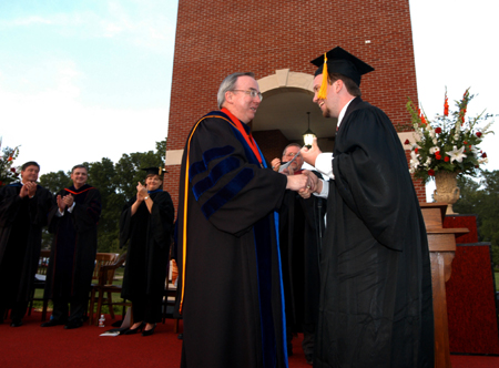Brian Taylor accepts the Tigrett Medal from President Dockery during spring graduation. Taylor has received a full fellowship and a $23,000 per year stipend for the next five years to do cancer research at M.D. Anderson hospital in Houston, Texas, the premier cancer research center in the country. His work will result in a doctorate from the University of Texas system in medical physics. 
