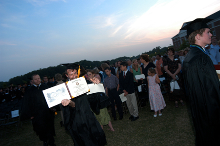Biology graduate Michael Kieffer shows off his diploma following the spring graduation ceremony.