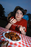 Graduating Senior Jodie Curtiss participates in a hotwings eating contest during the Happy Trails social at the Dockery's. - Photo by Morris Abernathy