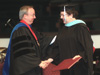 Sandra Allen, a staff member at Union University, receives her Master of Arts in Education degree from Dr. David S. Dockery, president of Union during the August 2002 graduation ceremony. - Photo by Jim Veneman