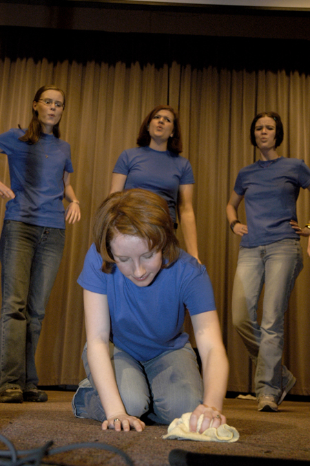 Senior Erin Hale washes the floor while Senior Laura Huggins, Sophomore Kelly Groover, Senior April Houston (back, left to right) whistle in the background during Sigma Alpha Iota's skit at Variety Show 2005.
