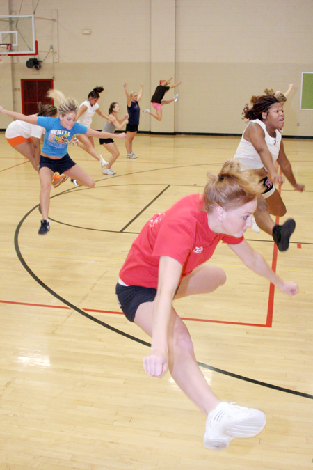 Junior Peaches Hughes, learning foundations
major, and several other girls practice their jumps at cheerleader tryouts.