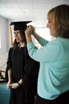 Learning Foundations Graduate Jennifer Sampson receives assistance with her cap before joining fellow graduates at fall graduation. - Photo by Brad Moore
