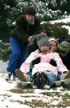 Cameron Armstrong, John Henson, and Brian Burns give Sarah Eastin and Brittany Sampson a little push while enjoying the snowy hill by the U. - Photo by Kyle Kurlick