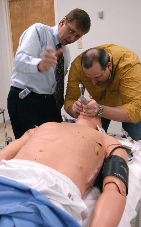 Mark Kossick, director of the nurse anesthesia program, demonstrates the Human Patient Simulator to graduate stuedent Dale Viox.